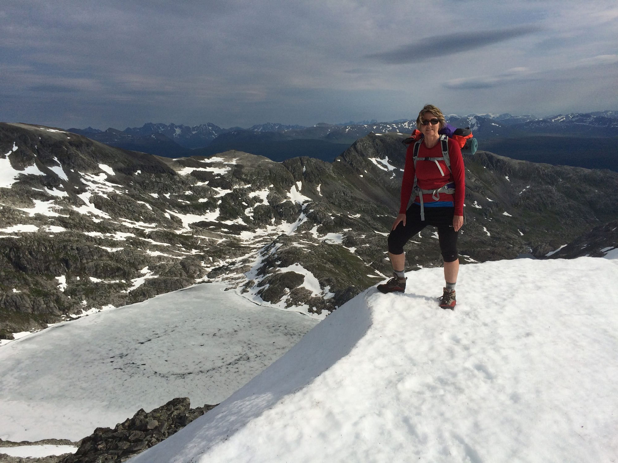 Helen på toppen av Breitind med fjellpanoramaet bak