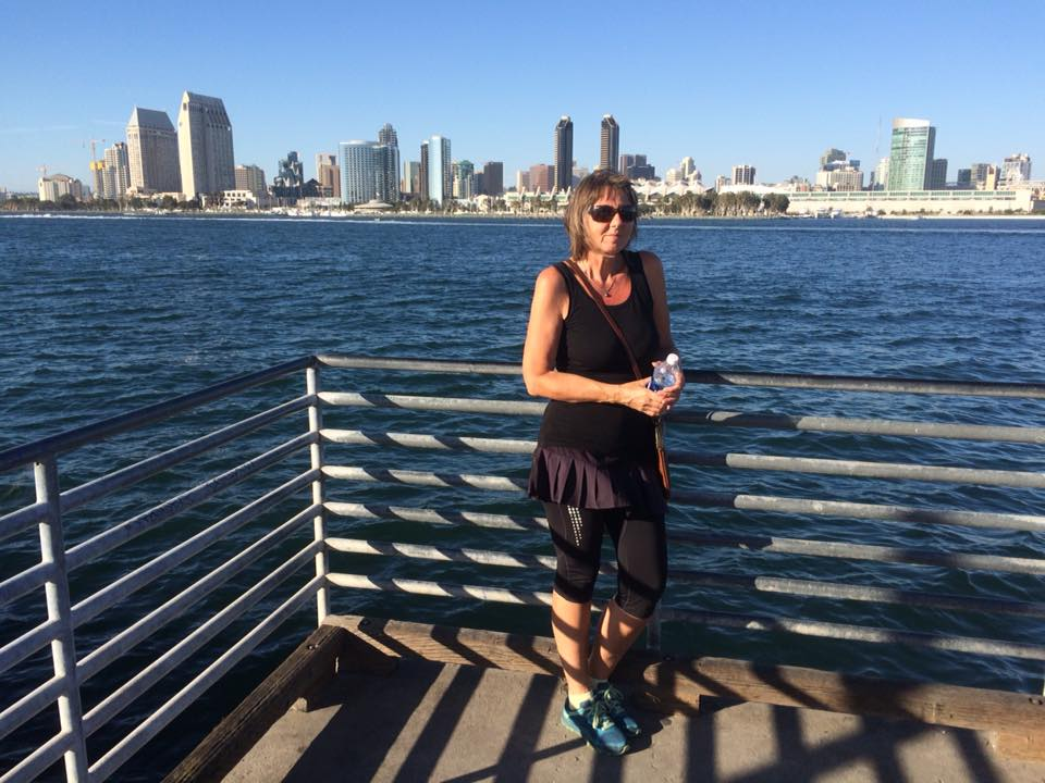 Helen på en brygge med skyline-en til downtown San Diego bak seg