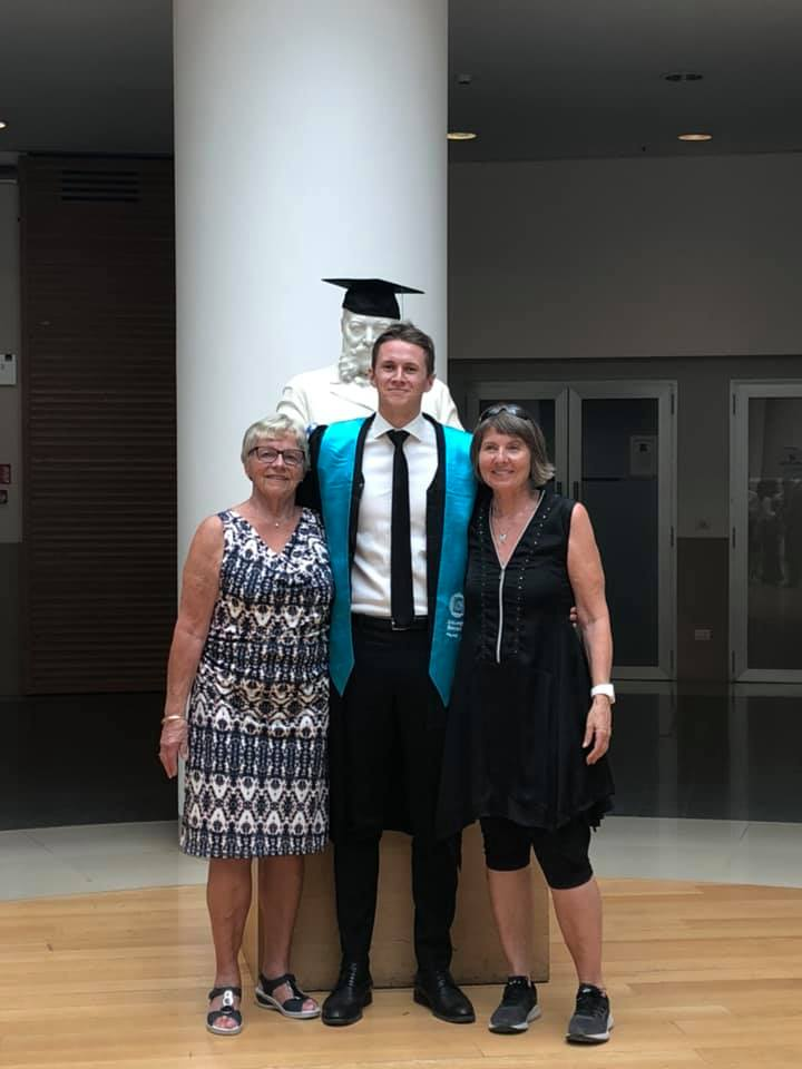 Helen og mormor med Edvin i kappe og diplomstjal etter mastergrad
