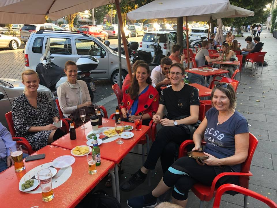 Helen sammen med Edvin og kollegene rundt et rødt bord ute på en bar i Roma