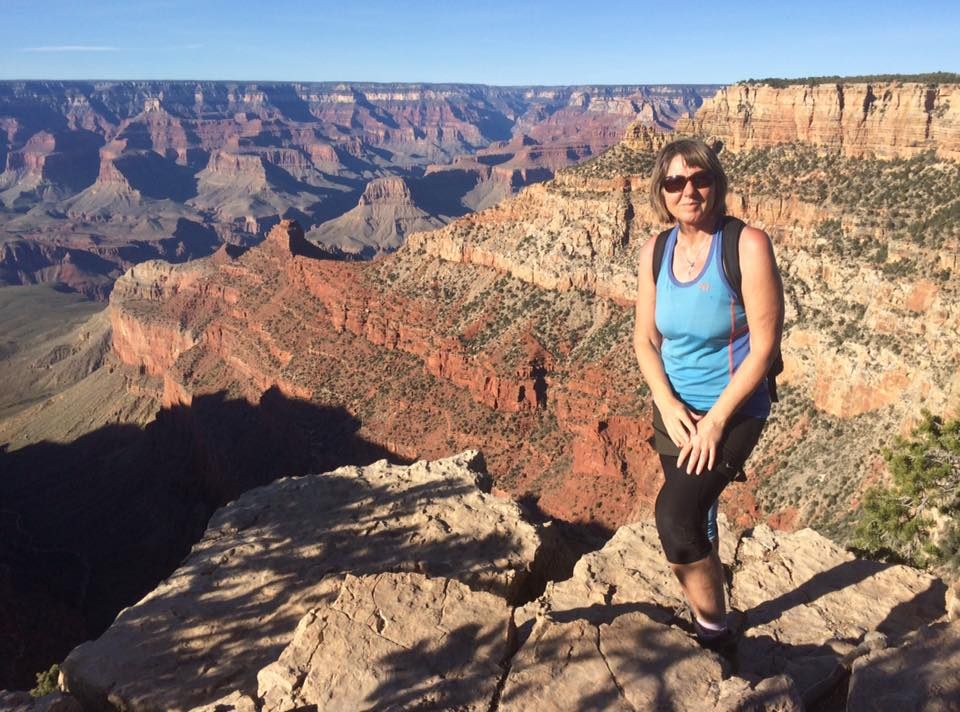 Helen på en stein ved kanten av Grand Canyon med utsikt over canyonen