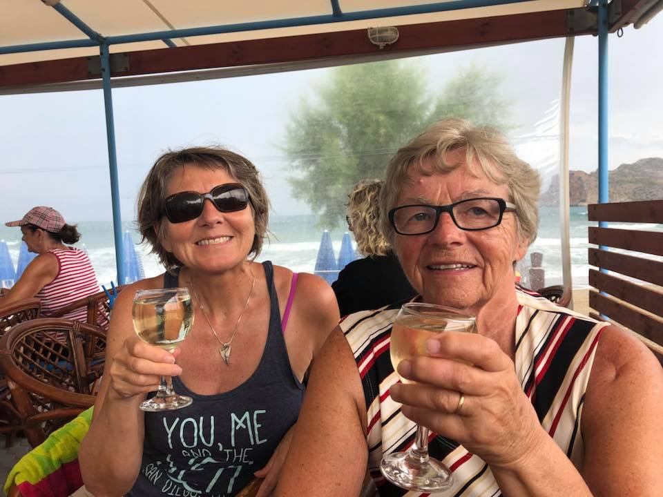 Helen og en venninne skåler med hvitvin på en strandbar mens regnet faller