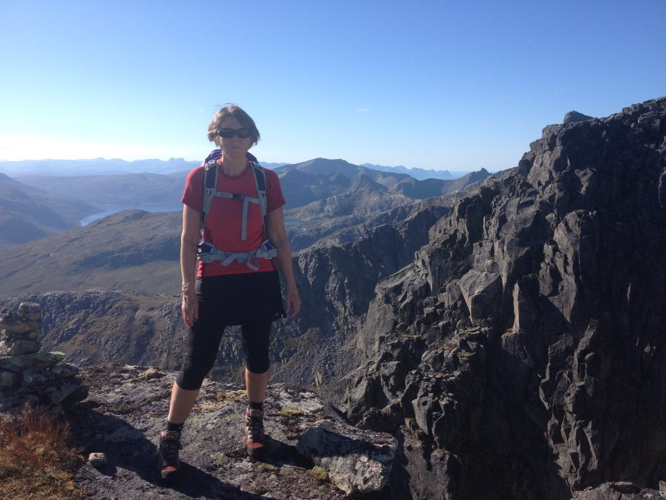 Helen på en fjelltopp med Kattfjorden i bakgrunnen
