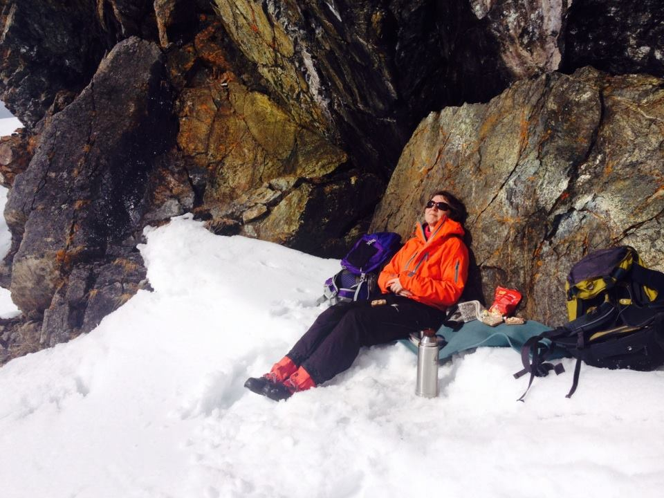 Helen tar pause i sola mot fjellveggen på Krutfjellet