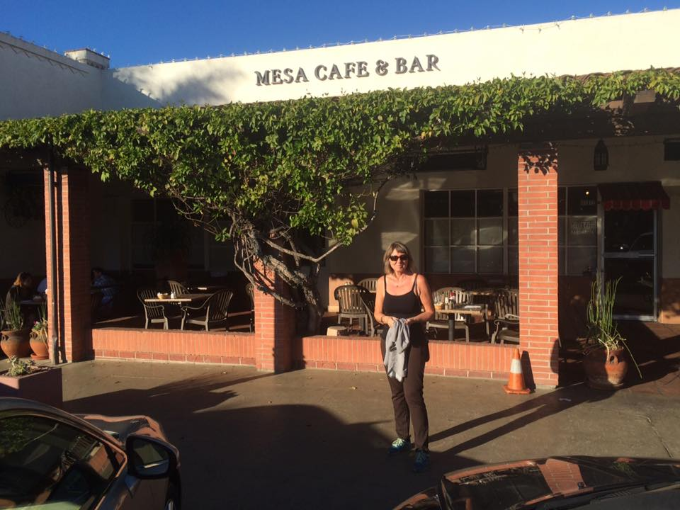 Helen utenfor inngangen til Mesa Cafe & Bar i ettermiddagssola