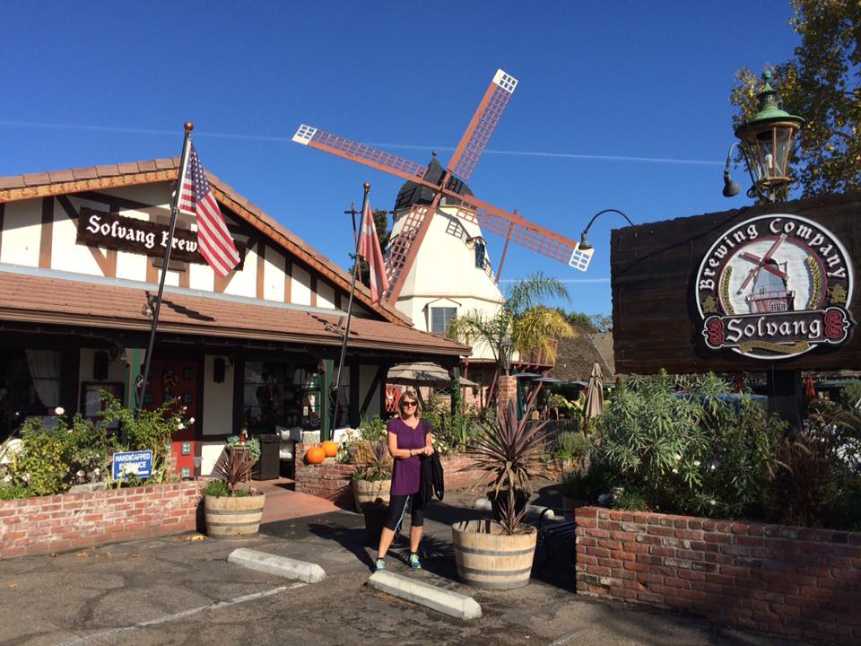 Helen utenfor Solvang Brewing Company med vindmølla i bakgrunnen