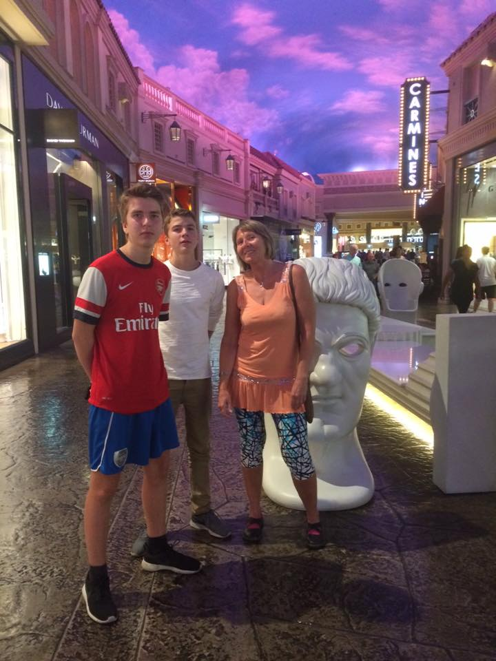 Helen og guttene ved et stort hvitt Caesar-hode i Forum Shops med lilla himmel over