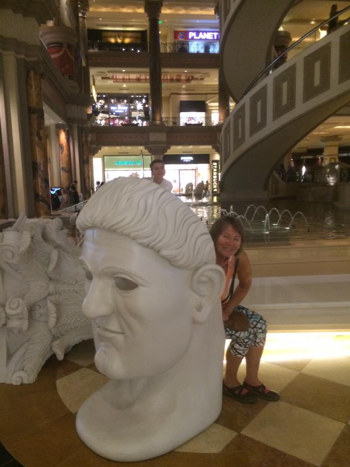 Helen lener seg leende inntil et romersk byste i Caesars Palace